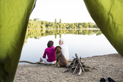 Senior couple camping with dog at a lake