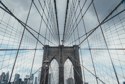 Low angle view of suspension bridge against sky