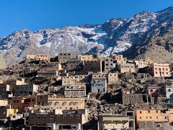 Aerial view of townscape and mountains against clear sky