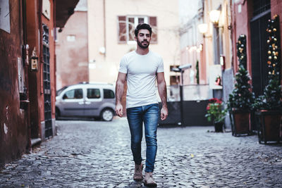 Full length portrait of young man standing in city