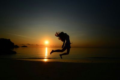 Silhouette of people on beach at sunset