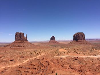 Rock formations in desert against blue sky