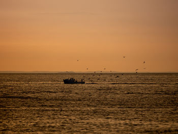 Scenic view of sea against orange sky