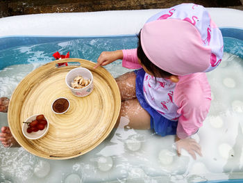 High angle view of cute girl sitting in water