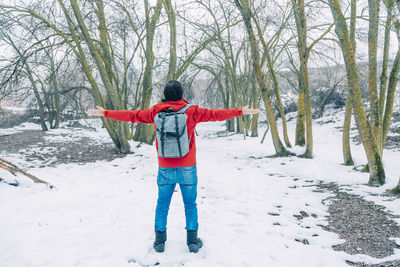 Rear view of woman standing on snow covered field