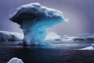 Scenic view of snow covered mountain against blue sky