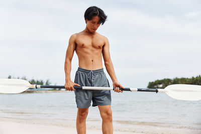 Rear view of shirtless man exercising in gym