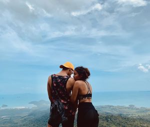 Rear view of couple standing against sky