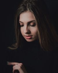 Portrait of beautiful woman against black background