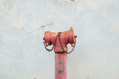 Rusty metal pipe against wall