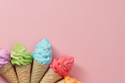 Various of colourful meringue ice cream cone on pink background