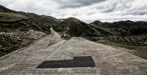 Road by mountain against sky