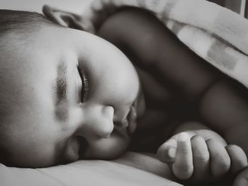 Close-up of baby girl sleeping on bed