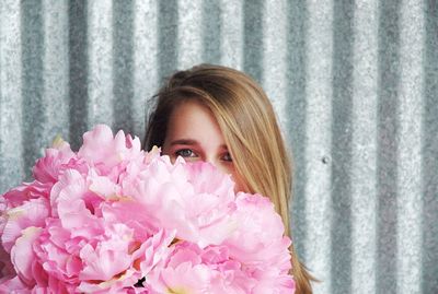 Portrait of young woman with pink flowers