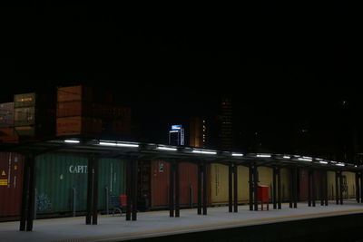 Illuminated railroad station against sky at night