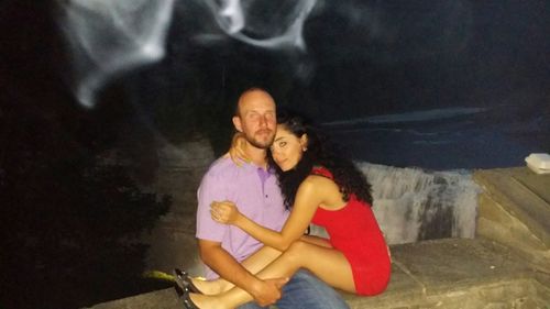 Portrait of young woman sitting on wall
