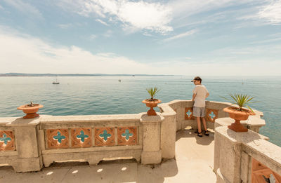 People looking at sea against sky