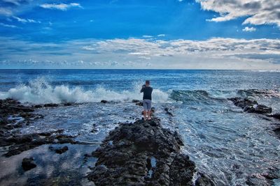 Rear view of man on beach against sky