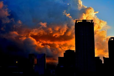 Modern cityscape against sky during sunset