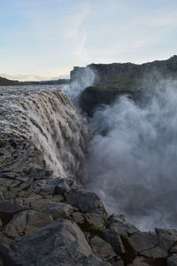 Scenic view of waterfall against sky