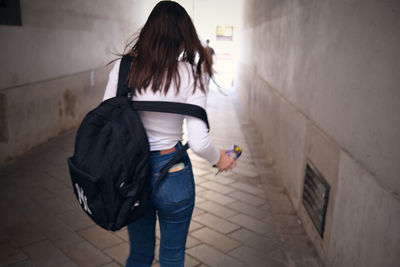 Rear view of woman walking on footpath