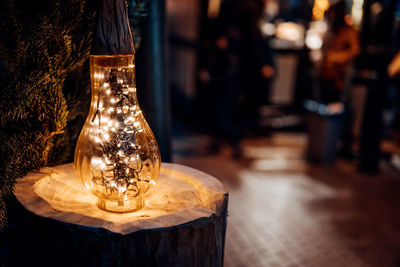 Close-up of illuminated lamp on table in restaurant