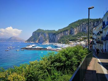 Scenic view of sea and mountains against blue sky