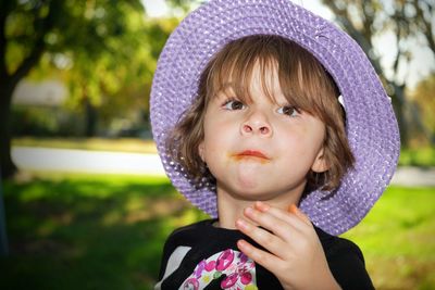 Close-up of girl wearing hat while looking up at park