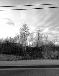 Power lines against cloudy sky