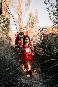 Family wearing santa costume walking in forest