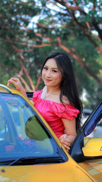 Portrait of woman standing by car