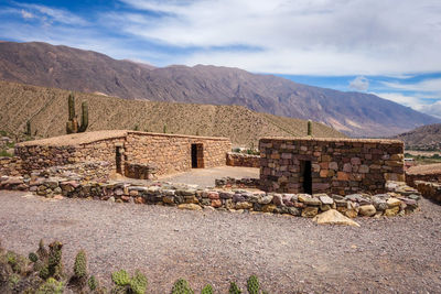 Houses by mountains against sky