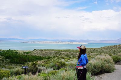 Rear view of woman looking at sea against sky