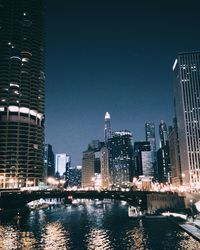 River with skyscrapers lit up at night