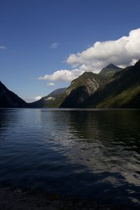 Scenic view of lake by mountains against sky