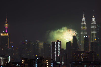 Illuminated cityscape against sky at night