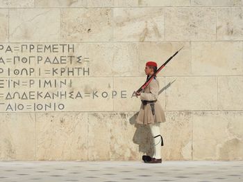 Full length of man standing against wall