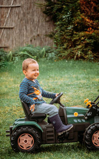 Boy sitting on toy tractor