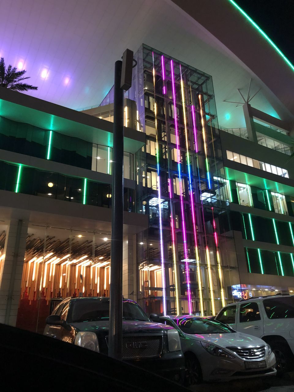 illuminated, architecture, car, night, building exterior, motor vehicle, city, built structure, mode of transportation, no people, transportation, land vehicle, lighting equipment, street, glowing, glass - material, multi colored, building, transparent, outdoors, nightlife