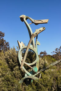 Low angle view of sculpture on field against clear sky