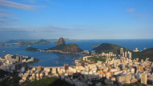 Tilt-shift shot of sugarloaf mountain and cityscape against sky