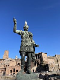 Low angle view of statue against blue sky