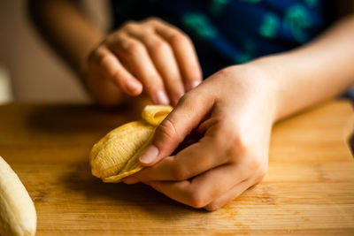 Cropped hands of person preparing food on table