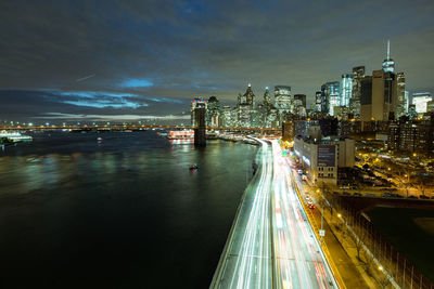 Illuminated light trails amidst buildings in city at night