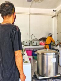 Rear view of man working in kitchen