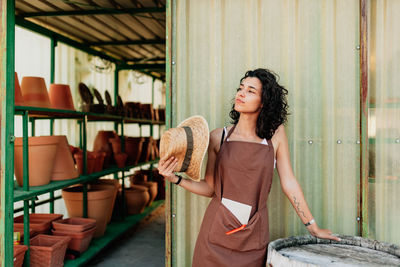 Young woman looking away while standing outdoors