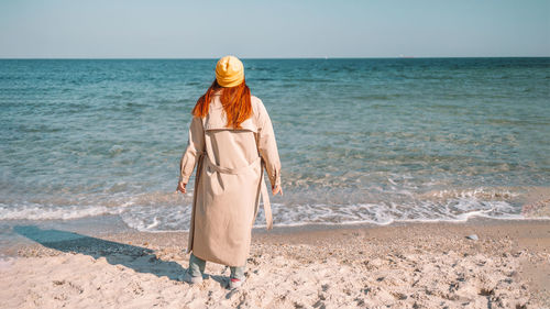 Rear view of woman standing on beach