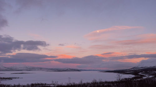 Scenic view of snowcapped landscape against sky during sunset