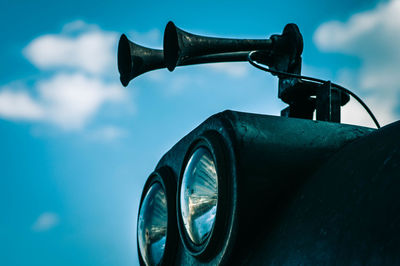 Close-up of vintage car against blue sky
