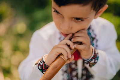 Boy holding instrument outdoors